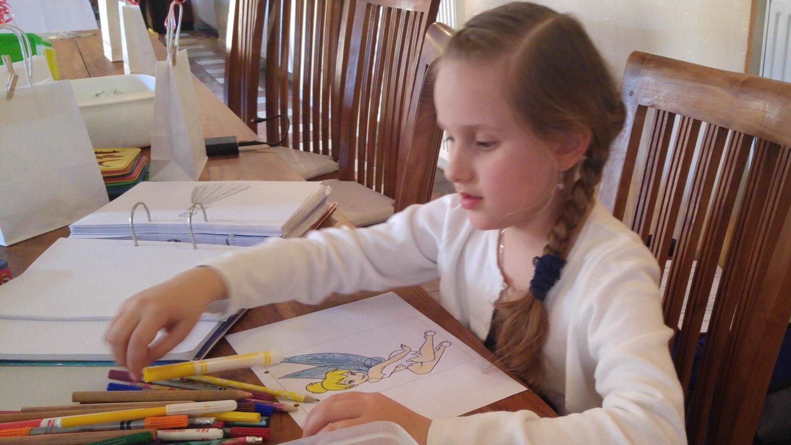 Child at wedding coloring while being supervised. One of many kid-friendly wedding ideas.